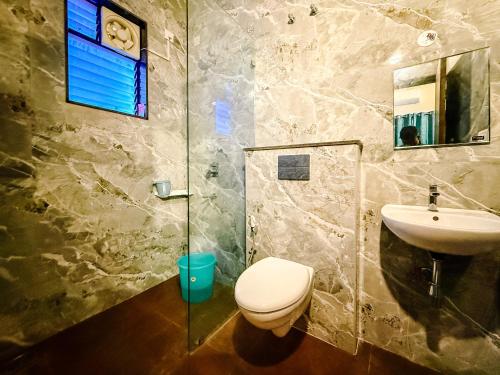 a bathroom with a toilet and a sink at SeaLara Resorts in Covelong