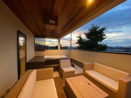 a balcony with white furniture and a large window at Kotohaku 木津町 in Kizugawa