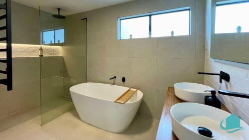 a bathroom with a tub and a sink and a shower at Casa Calvi - Central location with Pool in Jewells Station