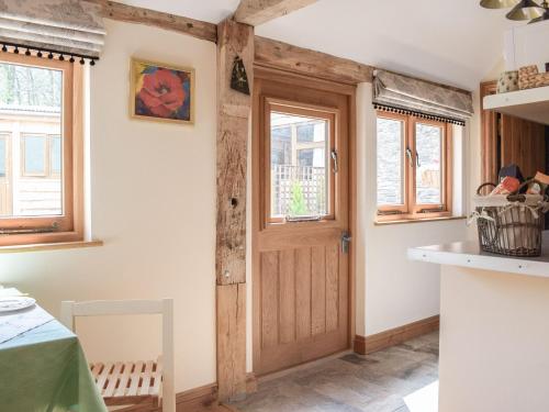 a kitchen with a wooden door and windows at Badgers Den - Uk32084 in Dorstone