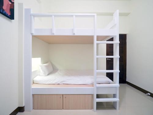 a bunk bed with a ladder in a room at Love and Peace B&B in Taitung City