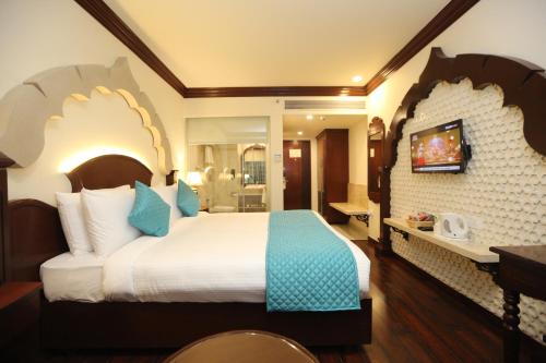 a hotel room with a large bed and a bathroom at Comfort Inn Sapphire - A Inde Hotel in Jaipur