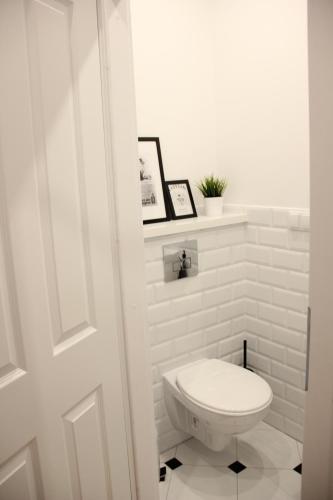 a white bathroom with a toilet in a room at Apartament z patio w centrum Starego Miasta in Toruń