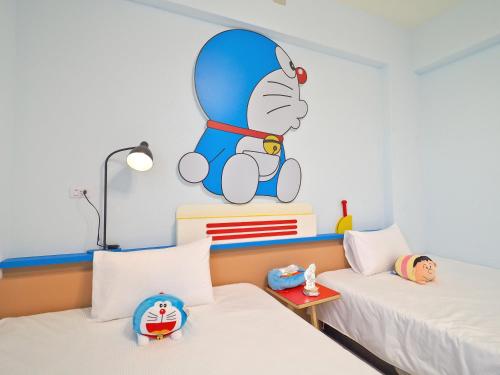 a bedroom with two beds with a mickey mouse mural on the wall at Love and Peace B&B in Taitung City