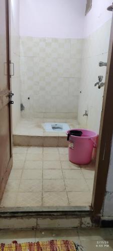 a bathroom with a tub and a bucket on the floor at Kurnool Homestay in Kurnool