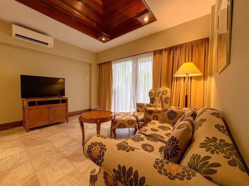 a living room with a couch and a television at Tiara Labuan Hotel in Labuan