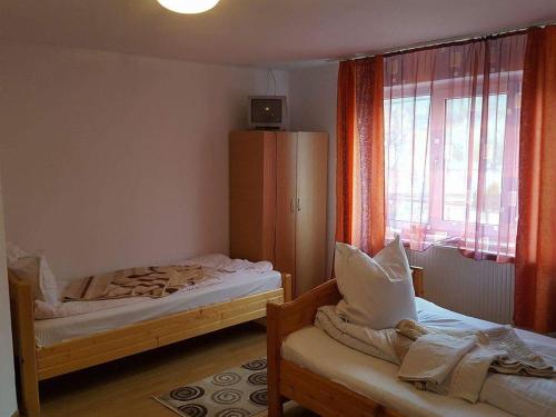 a bedroom with two beds and a window at Pensiunea Cristomar in Bran