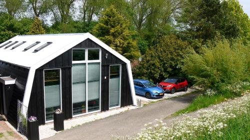 een zwart-witte garage met auto's geparkeerd op een parkeerplaats bij Markermeerlogies in Bovenkarspel