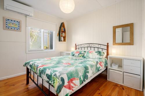 a bedroom with a bed with a green and white comforter at Pet Friendly Island Garden Retreat in Cowes in Cowes