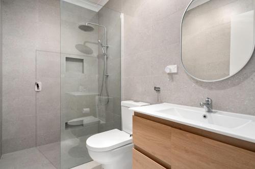 a bathroom with a toilet and a sink and a mirror at Pet Friendly Island Garden Retreat in Cowes in Cowes