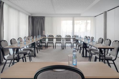 a conference room with long tables and chairs at HOTEL ALMOND BUSINESS & SPA BY GRANO - GRANO HOTEL Gdańsk Riverside in Gdańsk