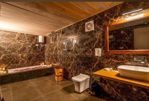 a bathroom with a sink and a toilet and a mirror at Desert Galaxy Camp - A Family Luxury Camp in Jaisalmer