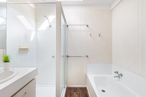 a white bathroom with a shower and a sink at Point Lonsdale Beach House - Relax Beach Surf Golf in Point Lonsdale