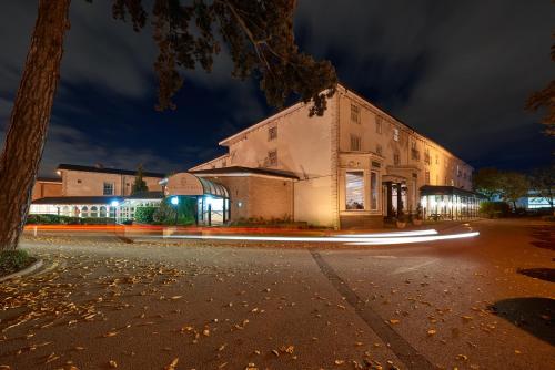 a building with lights on a street at night at The Regency Hotel in Solihull