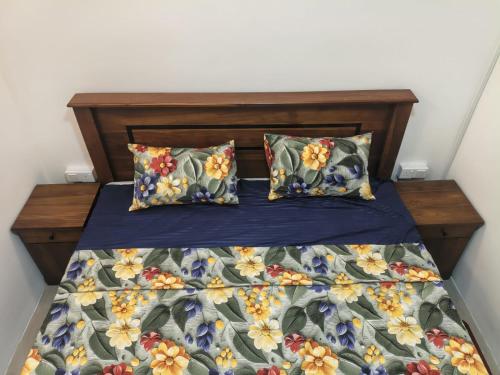 a bed with a blue comforter and two pillows at Minsara Villa in Ahangama