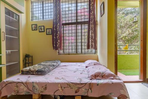a bedroom with a bed in front of a window at Forest View Penthouse Stay - PRIME HSR - Near NIFT in Bangalore