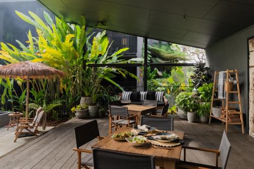 a patio with a table and chairs and plants at Imperial Boutique Accommodation in Eumundi