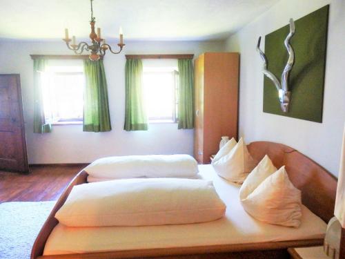 2 Betten in einem Zimmer mit grünen Vorhängen in der Unterkunft Ferienhaus Schmittenhof in Biberwier