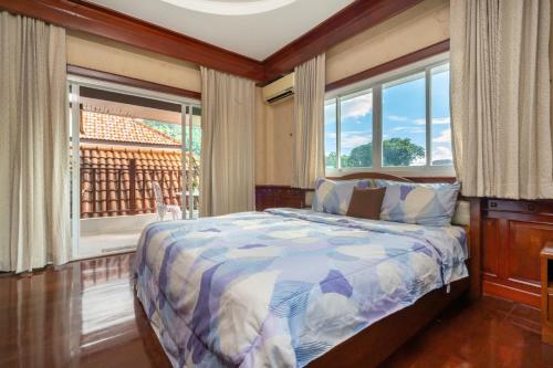 a bedroom with a bed and a window with a view at Cheeva Pool Villa Phuket in Phuket