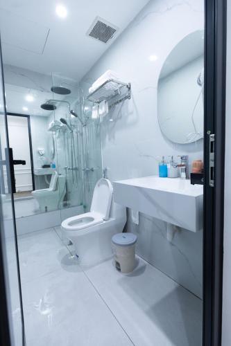 a white bathroom with a toilet and a sink at Anna Noi Bai Airport Hotel in Sóc Sơn