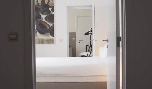 a view of a bedroom with a mirror and a bed at Les Chambres du Vaudeville in Brussels