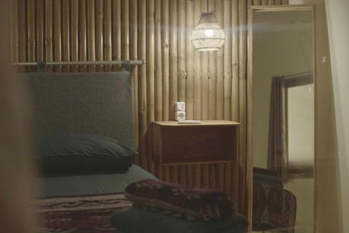 a bedroom with a bed and a mirror and a lamp at Kokomo Yogyakarta in Yogyakarta