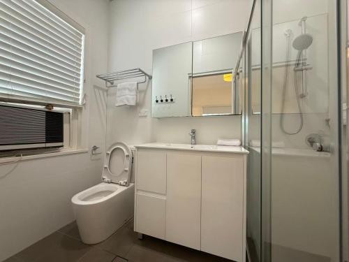 a bathroom with a toilet and a sink and a shower at Central Chatswood Urban Stay in Sydney