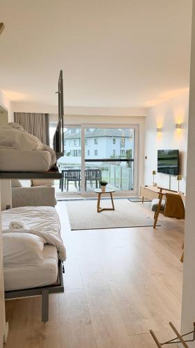 a bedroom with two beds and a view of a balcony at Cozy Studio with Pool in Middelkerke 4 Guests in Middelkerke
