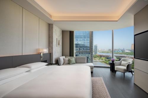 a hotel room with a large bed and a large window at Hyatt Regency Xi'An Chanba in Xi'an