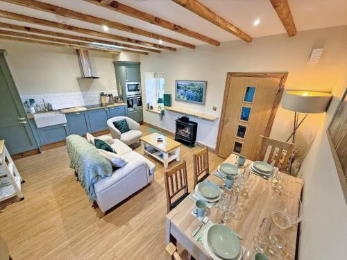 a living room with a couch and a table at Bumblebee Cottage-Uk39918 in Ballakinnag