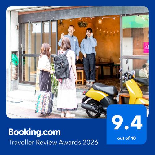 a group of people standing outside of a shop with a scooter at LovesunshineBackpackers in Tokyo