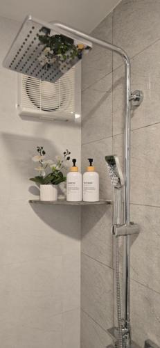 a shower with three shampoo bottles on a shelf in a bathroom at Nala Host - Maafushi Homes in Maafushi