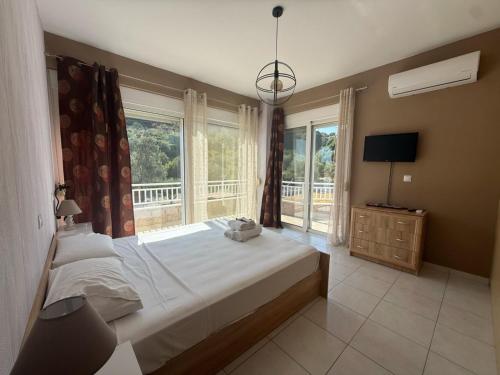 a bedroom with a bed and a large window at Casa Fountain Villa in Kolymbia