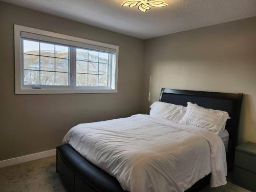 a bedroom with a large bed with a window at Harmony Haven in Drumheller in Drumheller