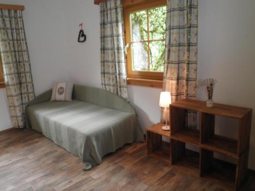 a room with a green couch and a window at Almurlaub Buchebnerreith, Ferienwohnungen in Hinterstoder