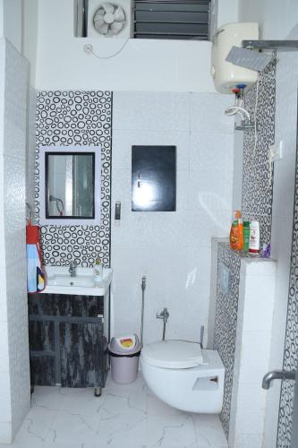 a white bathroom with a toilet and a sink at Angel's Cottage in Jaipur