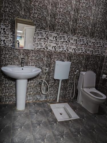 a bathroom with a sink and a toilet and a mirror at استراحة الأسطورة AlAstura rest in Al Ḩamrāʼ