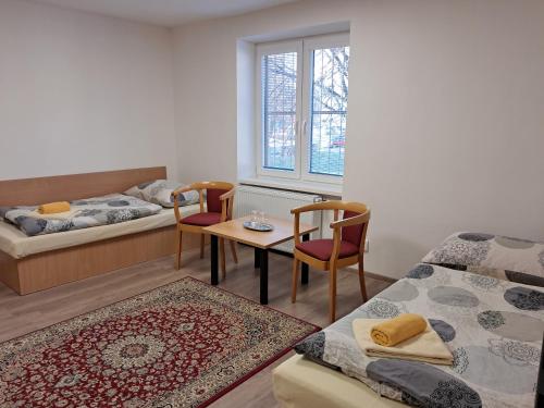 a room with two beds and a table and chairs at ŠD Němcovej 1 in Košice