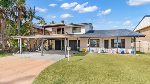 a house with a lawn in front of it at Driftwood At Beachmere in Beachmere