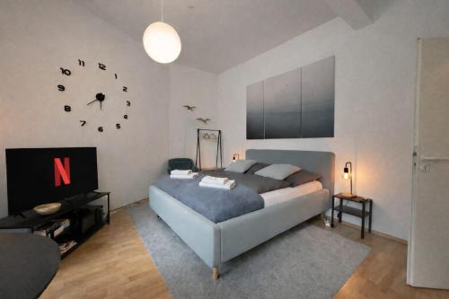 a bedroom with a bed and a clock on the wall at N&N City Apartment Schwerin mit Parkplatz in Schwerin