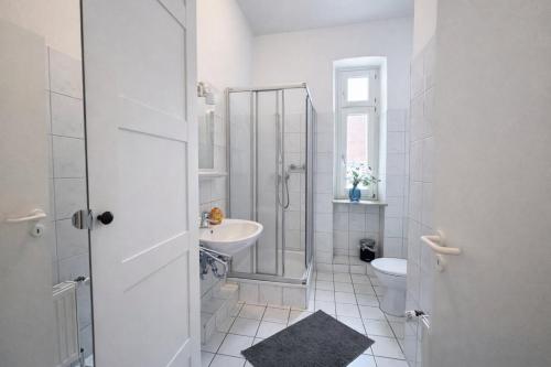 a white bathroom with a sink and a toilet at N&N City Apartment Schwerin mit Parkplatz in Schwerin