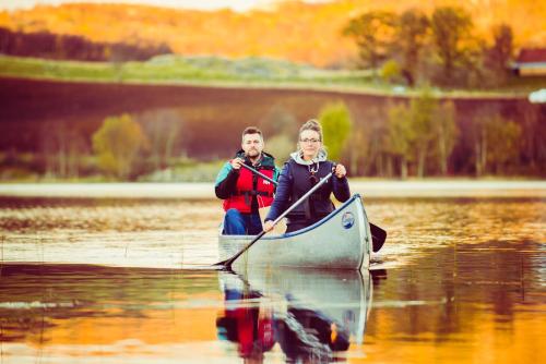a man and woman paddling a canoe on a lake at Kronen Gaard Hotel in Sandnes