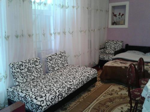 a living room with a couch and a chair at Ilgar's Hostel in Sheki