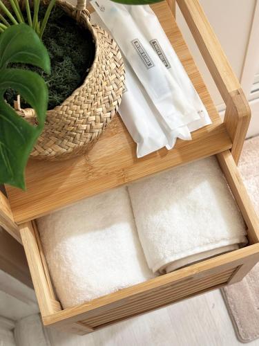 a wooden shelf with a potted plant and a basket at 지하철 2분, 침대3, 4인 최적, 5인 가능, 홍대 경복궁 명동 동대문 이동편리 in Samgong