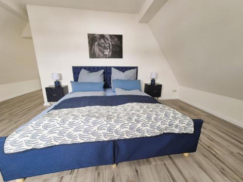 a bedroom with a large blue bed with blue pillows at Nordlandgiebel in Rosengarten