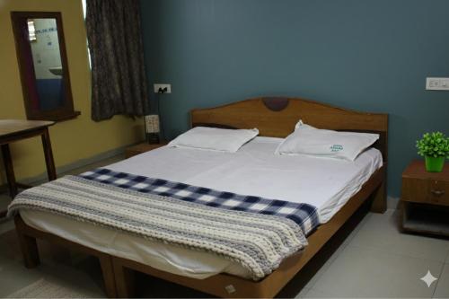 a bedroom with a bed with a checkered blanket on it at Anand Comfort in Anakāpalle