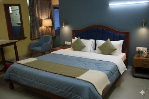 a bedroom with a large bed and a blue wall at Anand Comfort in Anakāpalle
