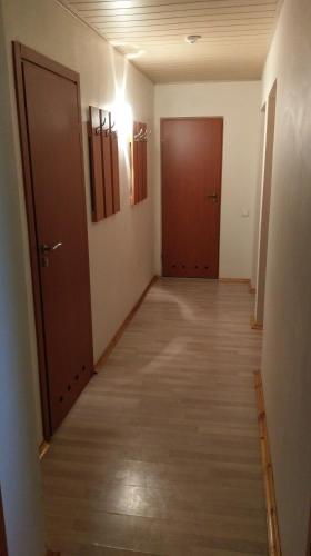 an empty hallway with two doors and wooden floors at Berzu aleja in Birštonas