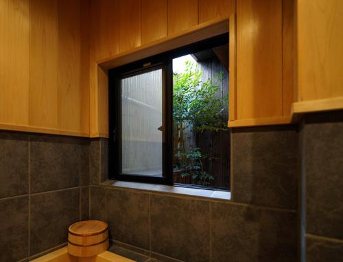 a window in a bathroom with a stool next to it at Shirakabanoyado-DOUNIWA, Private House Near Osaka Castle, 白樺の宿-堂庭 in Osaka