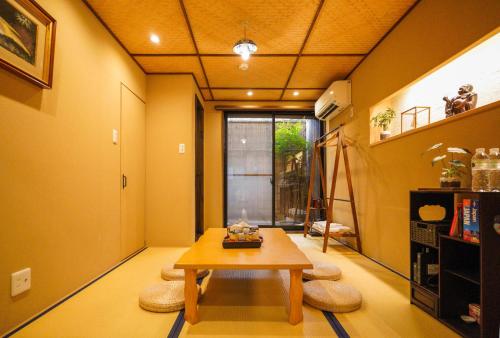 a living room with a table and some chairs at Shirakabanoyado-DOUNIWA, Private House Near Osaka Castle, 白樺の宿-堂庭 in Osaka